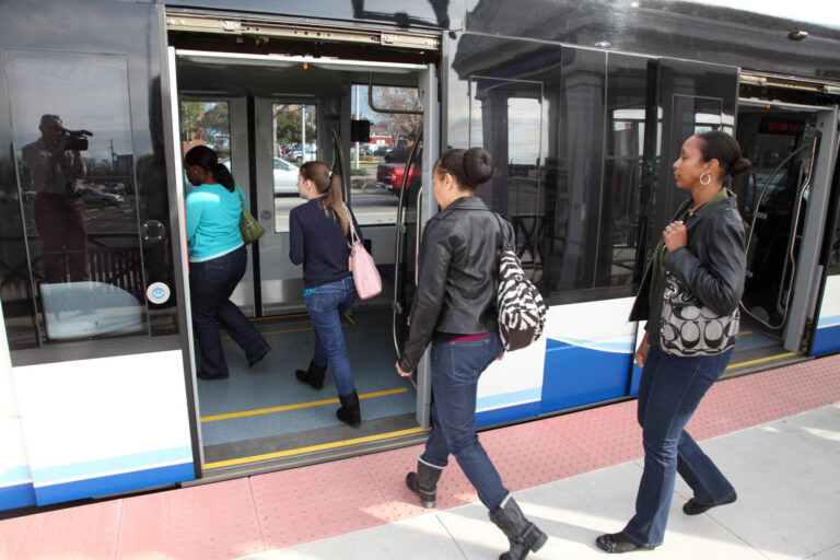 एचआरटी टाइड लाइट रेल सिस्टम पर हल्की रेल ट्रेन में सवार यात्रियों की फ़ोटोग्राफ़िक तस्वीर।